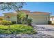 Inviting single-story home featuring well-maintained landscaping, paver driveway, and an attached two-car garage at 108 Corte Del Asolo, Venice, FL 34285