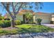 Inviting single-story home with lush landscaping, brick driveway, and a classic Mediterranean-style roof at 108 Corte Del Asolo, Venice, FL 34285