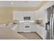 A kitchen featuring white appliances and cabinets, tile floors, and neutral countertops at 108 Corte Del Asolo, Venice, FL 34285