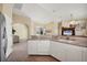 Spacious kitchen featuring white cabinetry, tiled floors, and a view into the dining and living areas at 108 Corte Del Asolo, Venice, FL 34285