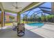 Screened in pool with bright blue water, seating, and green surroundings at 108 Corte Del Asolo, Venice, FL 34285