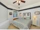 Cozy bedroom featuring a ceiling fan, black trim, and blue and white bedding at 11157 Batello Dr, Venice, FL 34292