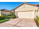 Close-up view of the well-maintained two-car garage with mature landscaping at 11157 Batello Dr, Venice, FL 34292