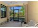 Enclosed lanai featuring a chair, concrete flooring, and expansive views of the lush backyard at 11157 Batello Dr, Venice, FL 34292