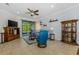 Cozy living room featuring tile flooring, ceiling fan, and sliding glass door to outdoor area at 11157 Batello Dr, Venice, FL 34292