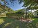 View of backyard featuring screened-in pool area with surrounding hedges and lawn at 117 Altesino Ct, Venice, FL 34292