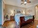 Cozy bedroom featuring hardwood floors, a ceiling fan, and beautiful decor at 117 Altesino Ct, Venice, FL 34292