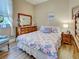 Charming bedroom with wood floors, floral bedding, and a large wooden dresser at 117 Altesino Ct, Venice, FL 34292