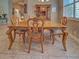 Traditional dining room featuring a wooden table, chairs, and display cabinet, bathed in natural light from a nearby window at 117 Altesino Ct, Venice, FL 34292