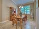 Well-lit dining area features tile floors, a wooden dining set, a decorative statue, and a large window with shutter blinds at 117 Altesino Ct, Venice, FL 34292