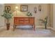 The foyer is decorated with flowers, a wooden cabinet, and plants to add a touch of elegance at 117 Altesino Ct, Venice, FL 34292