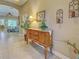Tiled entryway with a classic wooden cabinet, decor items, and a view into the living area at 117 Altesino Ct, Venice, FL 34292