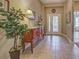 Welcoming tiled foyer area with decorative furniture, art, and a view of the glass-paneled front door at 117 Altesino Ct, Venice, FL 34292