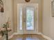 Interior view of a tiled foyer featuring a glass paneled front door and sidelight at 117 Altesino Ct, Venice, FL 34292