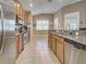 Well-equipped kitchen boasts stainless steel appliances, granite countertops, and ample cabinet space, enhanced by bright, natural light at 117 Altesino Ct, Venice, FL 34292