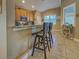 Stylish eat-in kitchen featuring sleek bar stools, granite countertops, and stainless steel appliances, perfect for casual dining at 117 Altesino Ct, Venice, FL 34292