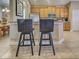 This kitchen features a breakfast bar with two dark stools at 117 Altesino Ct, Venice, FL 34292