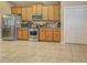 Bright kitchen with stainless steel appliances, wooden cabinets, and tile floors at 117 Altesino Ct, Venice, FL 34292