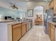 Open concept kitchen with stainless appliances, granite counters, tile floor, and view into the dining room at 117 Altesino Ct, Venice, FL 34292