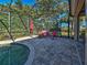 Covered patio with comfortable seating area overlooks a refreshing pool and beautifully landscaped backyard at 117 Altesino Ct, Venice, FL 34292
