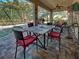 Screened patio features an outdoor dining set, ceiling fan, and tranquil views of the pool and backyard at 117 Altesino Ct, Venice, FL 34292