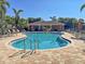 Community pool area featuring a clubhouse, lounge chairs, and palm trees at 117 Altesino Ct, Venice, FL 34292