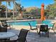 Relaxing poolside featuring tables, chairs, and sun umbrellas at 117 Altesino Ct, Venice, FL 34292