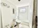 Bright bathroom featuring a white tub, toilet, medicine cabinet, and unique crystal light fixture above the commode at 1170 Little Ct, Englewood, FL 34223