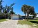 Cozy single-story home with a brick driveway, attached garage, and mature palm trees at 1170 Little Ct, Englewood, FL 34223