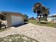 Single-story home featuring a brick driveway and mature palm trees at 1170 Little Ct, Englewood, FL 34223