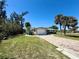 Charming single-story home with a brick driveway and a well-manicured lawn with mature palms at 1170 Little Ct, Englewood, FL 34223