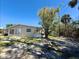 Side view of home featuring a well-maintained lawn and mature trees at 1170 Little Ct, Englewood, FL 34223