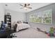 Neutral bedroom with light gray walls, large window, ceiling fan, and carpeted floor at 11910 Petunia Ter, Bradenton, FL 34212