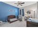 Calm Bedroom with a crib, glider, blue accent wall and lots of natural light at 11910 Petunia Ter, Bradenton, FL 34212