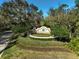 Elegant 'Greyhawk Landing' entrance sign set amidst manicured landscaping and mature trees at 11910 Petunia Ter, Bradenton, FL 34212