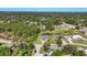 Aerial view of a residential neighborhood surrounded by mature trees and a small pond at 1207 Henning St, North Port, FL 34288