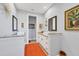 A modern bathroom featuring double sinks, granite countertops, white cabinetry, and an eye catching orange rug at 1207 Henning St, North Port, FL 34288