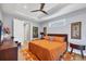A cozy bedroom with tray ceilings, a ceiling fan, neutral walls, and a large bed with decorative pillows at 1207 Henning St, North Port, FL 34288