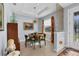 A dining room features a round table, light fixture, cabinet, and decorative geometric accent wall by the front door at 1207 Henning St, North Port, FL 34288