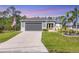 Inviting single Gathering home featuring a lush green lawn, palm tree, and spacious driveway at 1207 Henning St, North Port, FL 34288