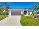 Charming single-Gathering home features a manicured lawn, palm tree, and a driveway at 1207 Henning St, North Port, FL 34288