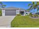 Charming single-story home with well-maintained lawn, gray exterior, and a two-car garage at 1207 Henning St, North Port, FL 34288