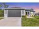 Attached two-car garage with extended driveway, lush lawn, and fresh landscaping at 1207 Henning St, North Port, FL 34288