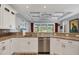 A bright kitchen features granite countertops, white cabinets, stainless steel appliances, and an attractive window view at 1207 Henning St, North Port, FL 34288