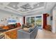 Comfortable living room featuring tray ceilings, a large television, and sliding glass doors to patio at 1207 Henning St, North Port, FL 34288