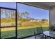 Enjoy pond views from this peaceful, screened-in patio with seating and access to the backyard at 1207 Henning St, North Port, FL 34288