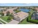 Aerial view of a community home featuring a tile roof, lush landscaping, and lakefront property at 12127 Granite Woods Loop, Venice, FL 34292