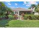 Landscaped backyard with lush greenery, a stepping stone path, and a view of the screened-in lanai at 12127 Granite Woods Loop, Venice, FL 34292