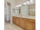 Double vanity bathroom with tile floor, walk in closet and walk-in shower at 12127 Granite Woods Loop, Venice, FL 34292