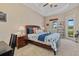Cozy bedroom with ceiling fan, tray ceiling and ensuite lanai access at 12127 Granite Woods Loop, Venice, FL 34292